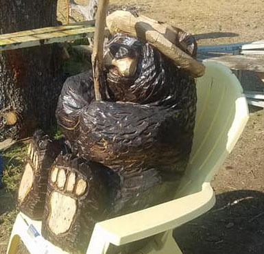 Bear in a chair by Kerr Chainsaw Carving